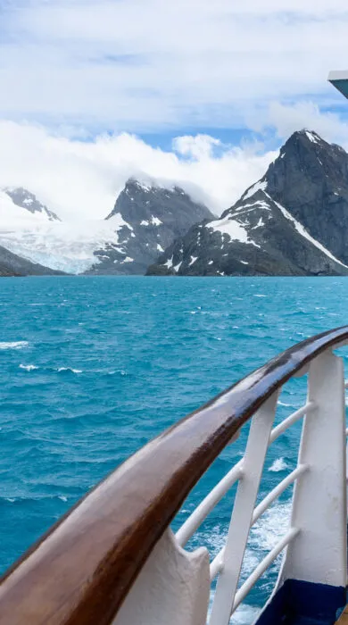 Towering snow-capped mountains and frozen waters, showcasing the remote beauty of an Antarctica expedition vacation.