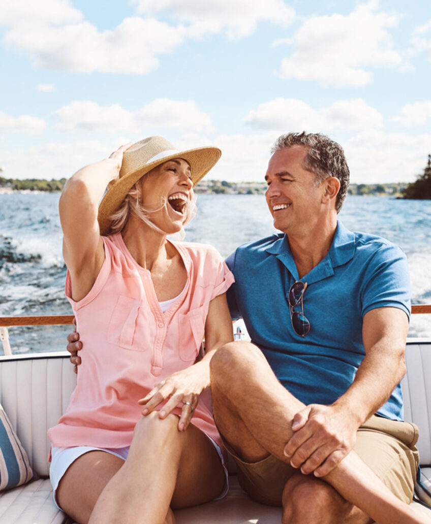 Smiling couple enjoying ocean views from a luxury cruise ship balcony, perfect for romantic sea vacations.
