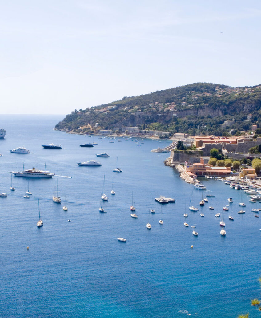 Elegant cruise ship docked near tropical island with clear blue water