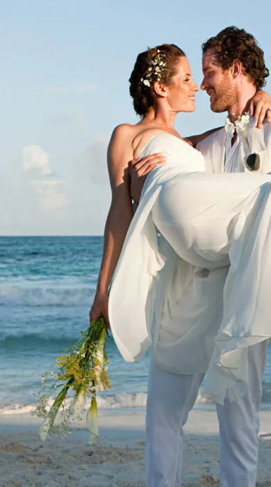 Newlyweds walking on a tropical beach, ideal for luxury honeymoon vacations and romantic destination weddings