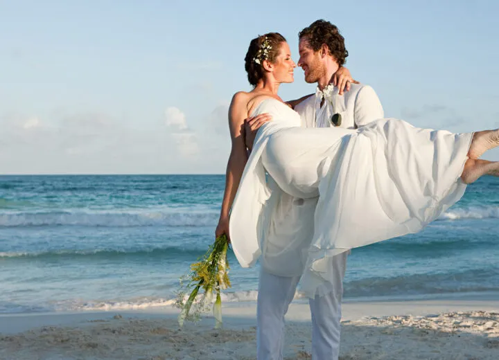 Newlyweds walking on a tropical beach, ideal for luxury honeymoon vacations and romantic destination weddings