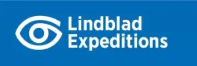 Luxury cruise ship sailing through icy Arctic waters with snow-covered mountains in the background