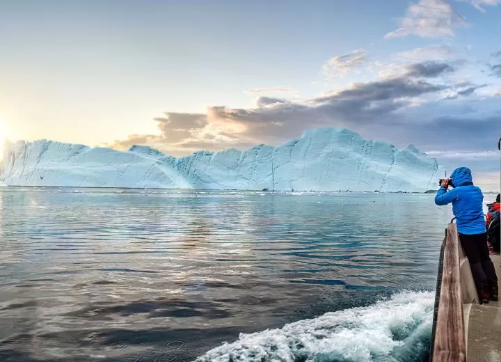 Expedition cruise ship sailing near icy polar landscapes.