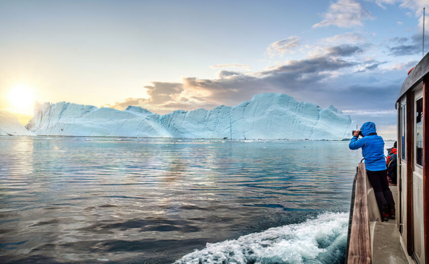 Expedition cruise ship sailing near icy polar landscapes.