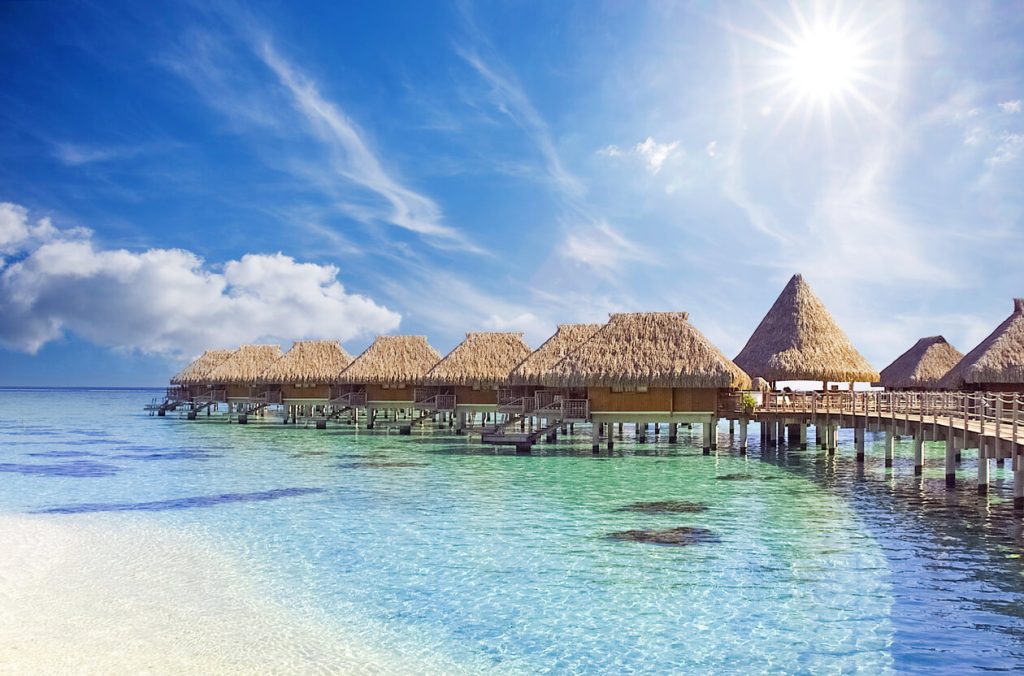Tropical Overwater Villas Under Sunny Sky Luxury overwater bungalows on turquoise lagoon