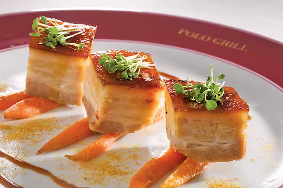 Oceania Cruises Dessert Experience – Chocolate Indulgence | Travel Adventures Unlimited Gourmet chocolate dessert with caramel drizzle and praline decoration served on Oceania Cruises