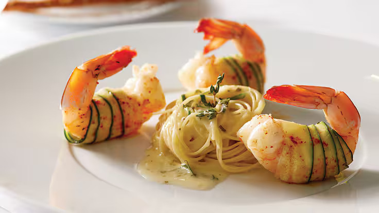 Zucchini-wrapped shrimp with pasta and creamy sauce served in Oceania Cruises’ gourmet dining room