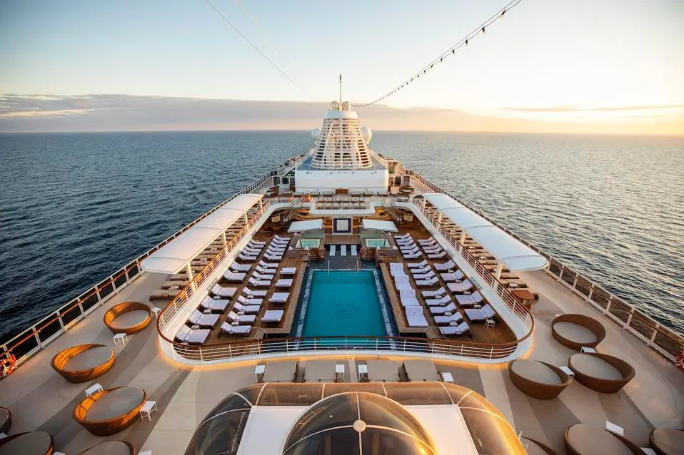 Luxury pool deck aboard Regent Seven Seas cruise ship at sunset, surrounded by ocean views